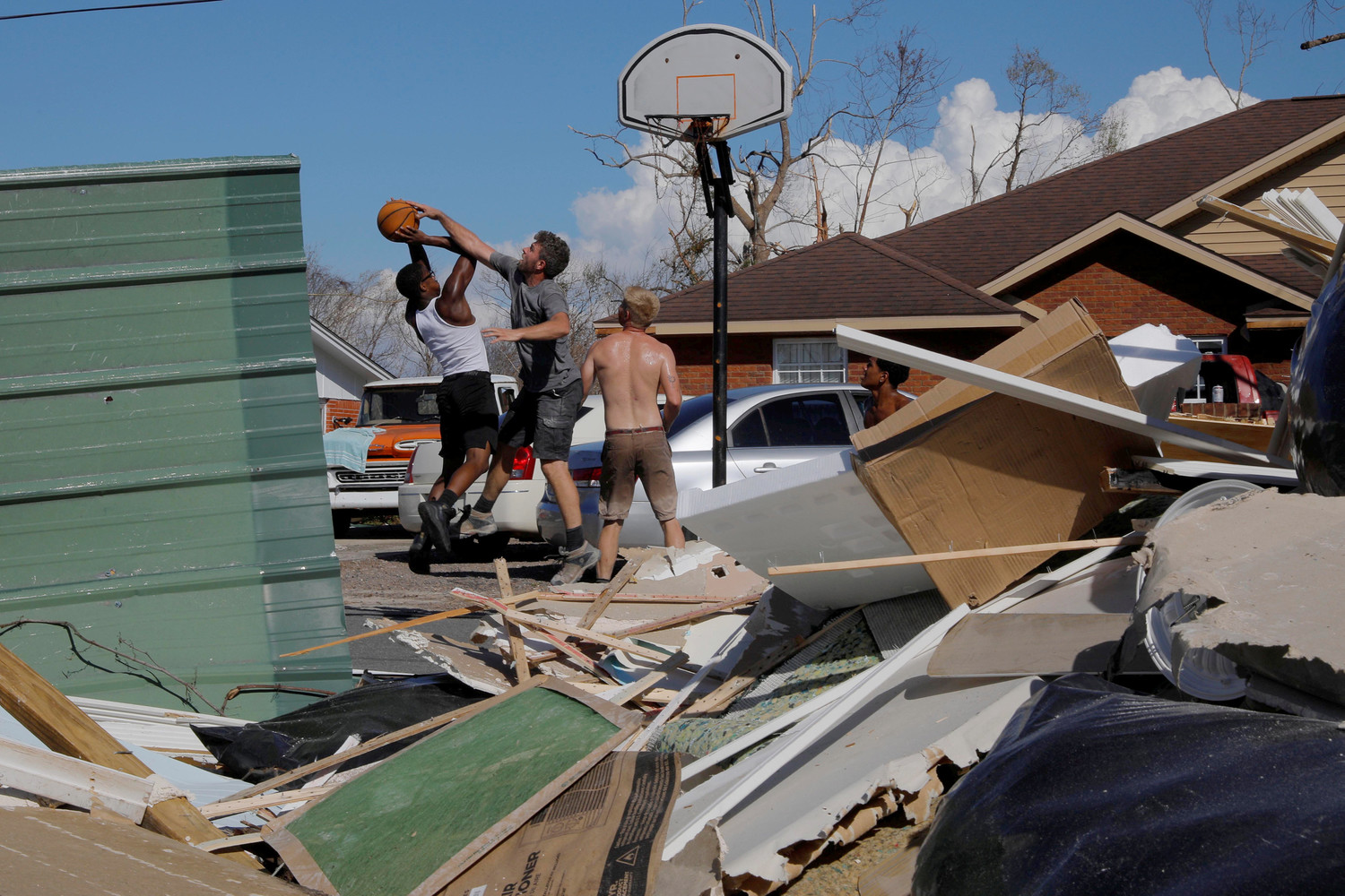 Contractors play basketball with residents amid debris Oct. 16 in the aftermath of Hurricane Michael in Springfield, Fla. The hurricane killed at least 16 people in Florida, most of them in the coastal county that took a direct hit from the storm, state emergency authorities said. That’s in addition to at least 10 deaths elsewhere across the South.